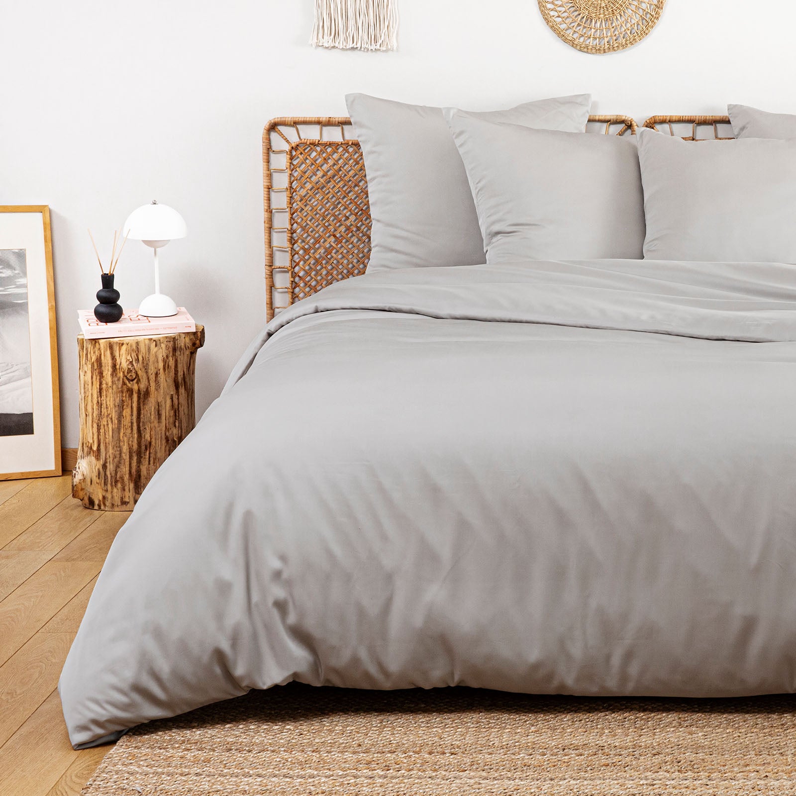 Neatly made bed with gray bedding in a bedroom setting.