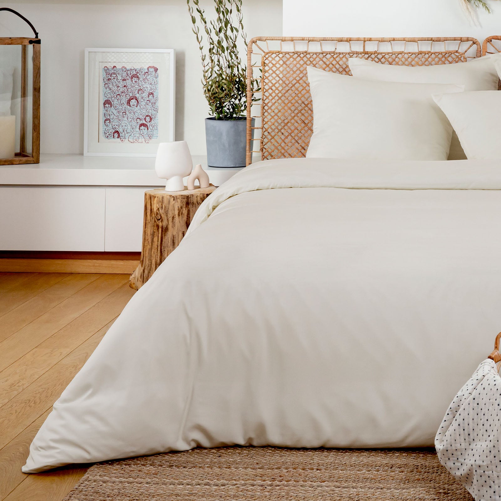 Neatly made bed with ivory bamboo bedding in a bedroom setting.