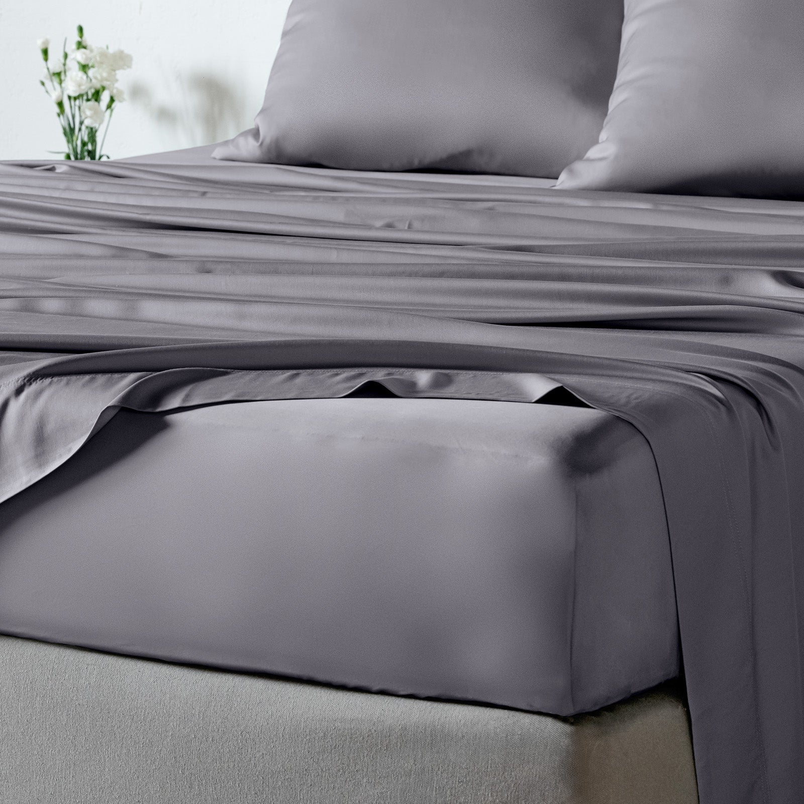 bambaw cozy bamboo bed sheets close up on a bed with fitted sheets and pillows in grey colour