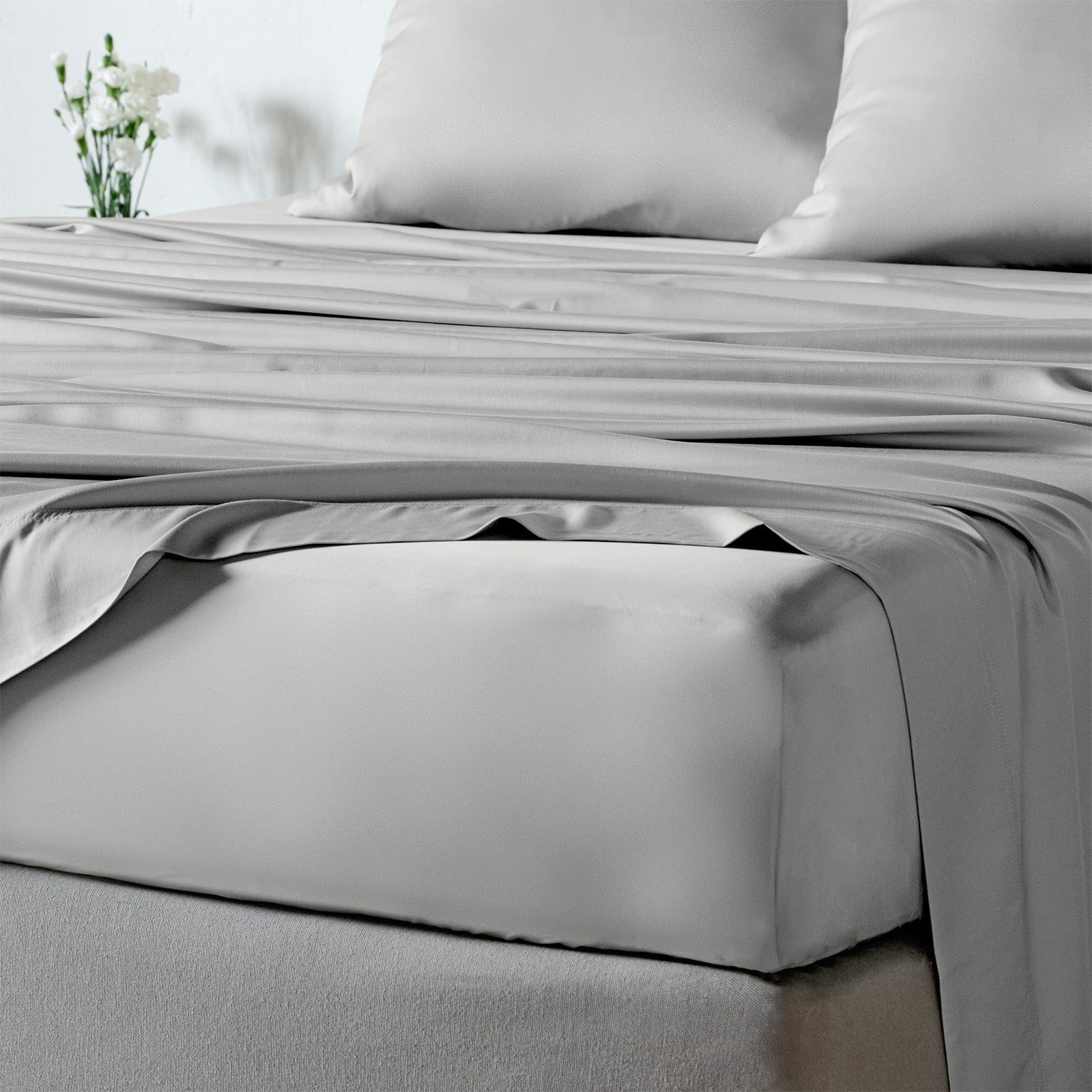 bambaw cozy bamboo bed sheets close up on a bed with fitted sheets and pillows in ight grey colour