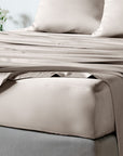 bambaw cozy bamboo bed sheets close up on a bed with fitted sheets and pillows in sand beige colour