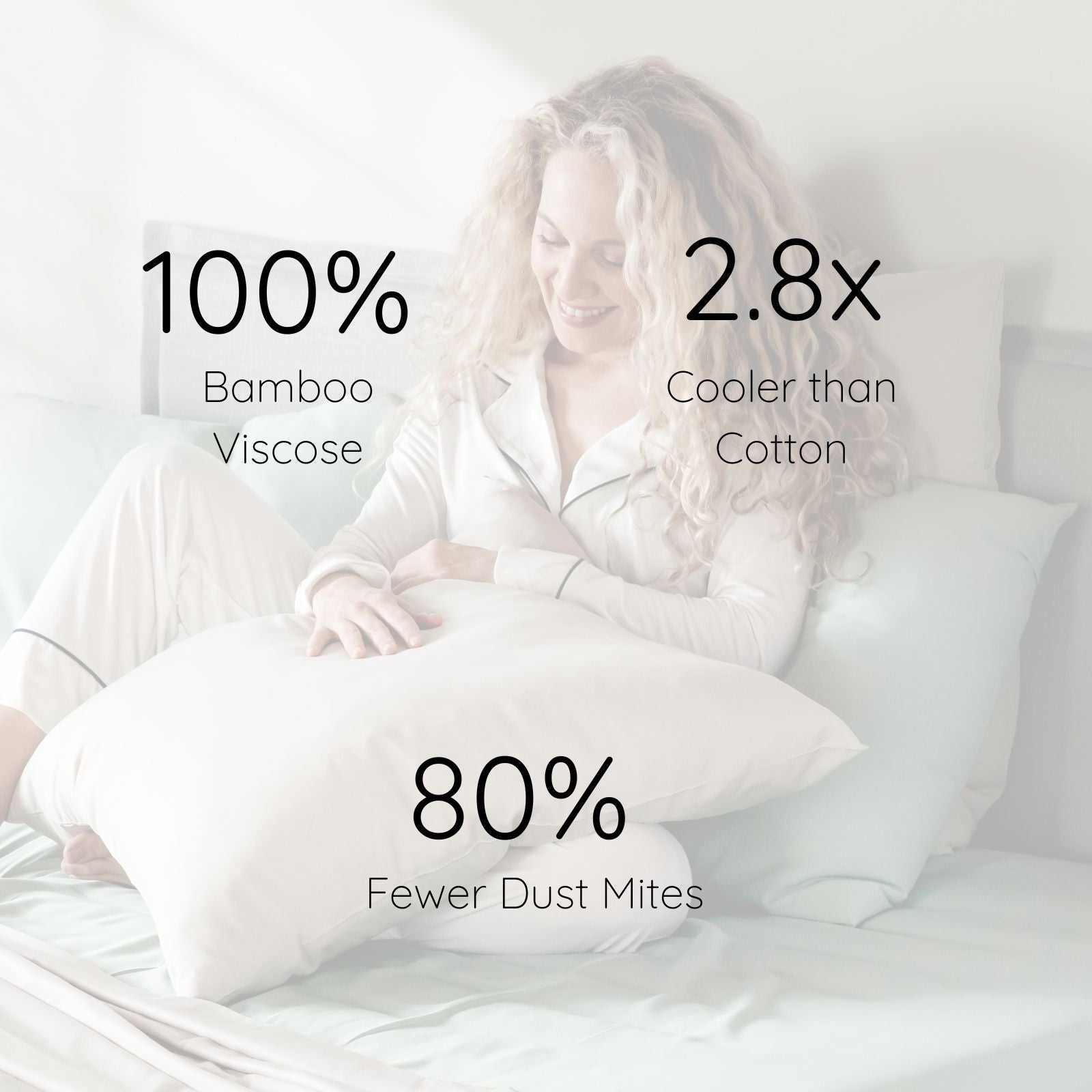 A woman in light pajamas sits on a bed holding a large sand colour bamboo viscose pillow, with overlaid marketing text reading '100% Bamboo Viscose,' '2.8x Cooler than Cotton,' and '80% Fewer Dust Mites.