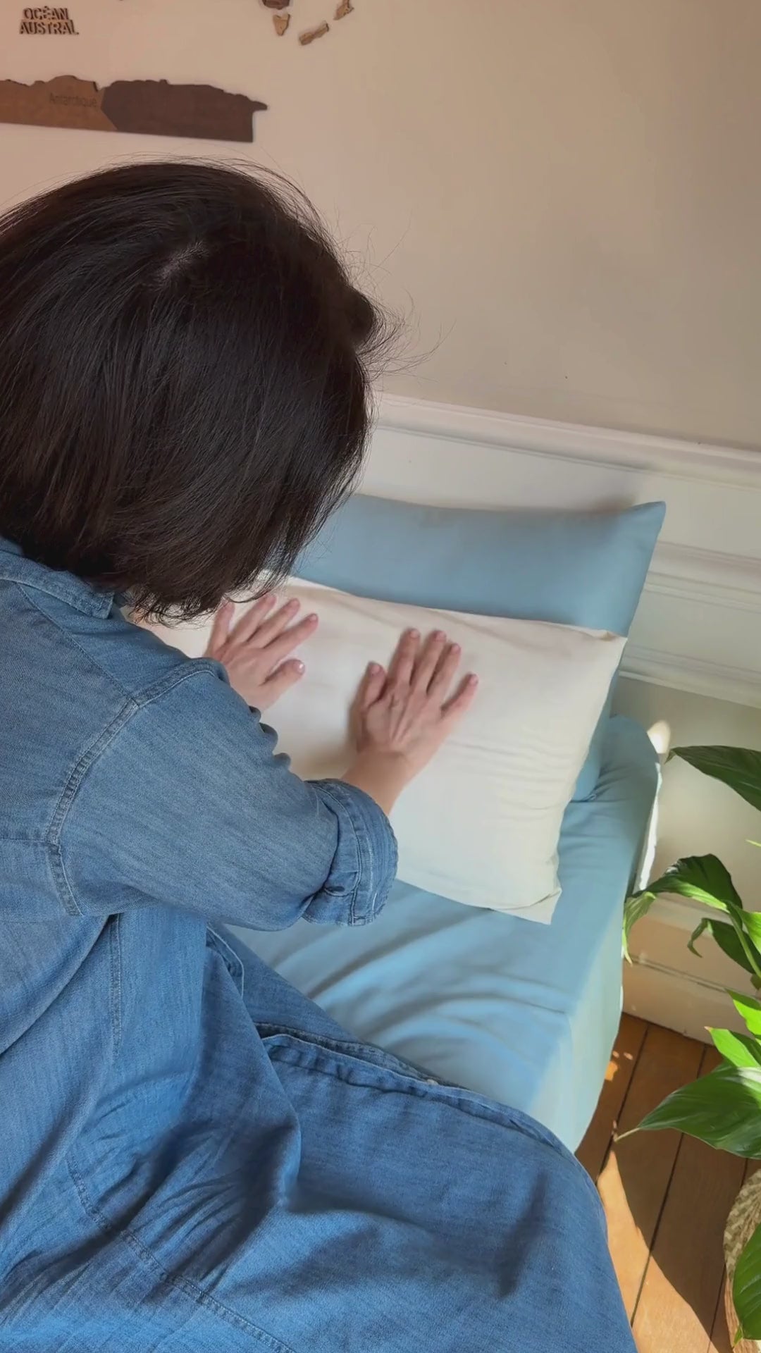a video of a woman unpacking light blue and white bamboo bedding set with pillowcases, fitted sheet, flat sheet and duvet cover